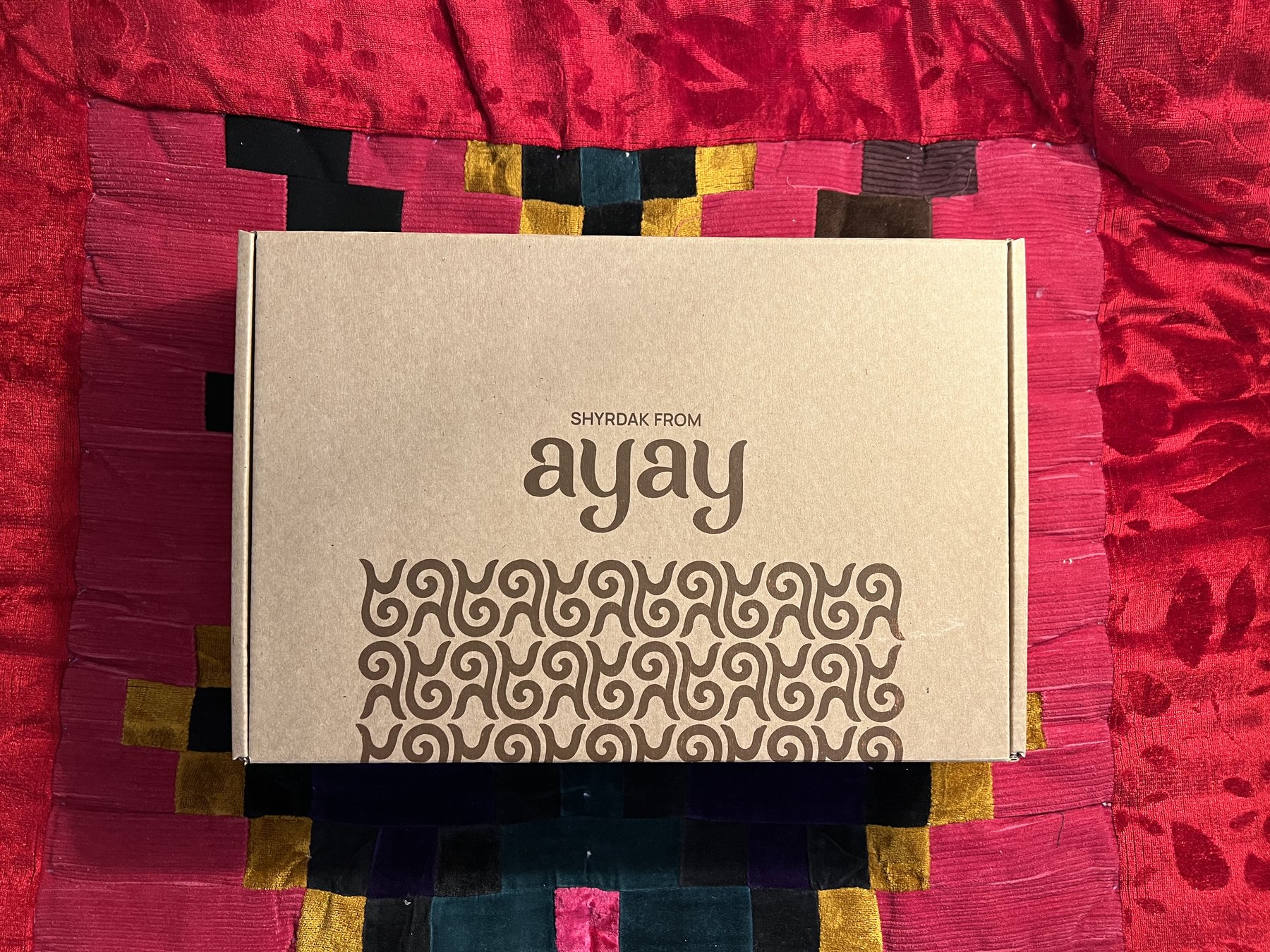Закрытая коробка набора AYAY на красном текстиле